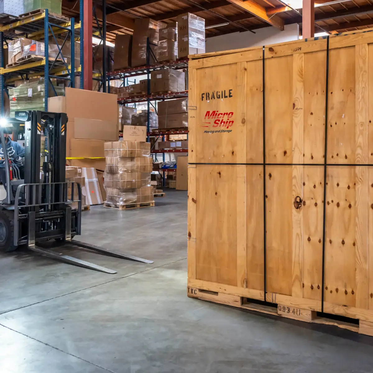 A forklift is moving a large wooden crate in a warehouse