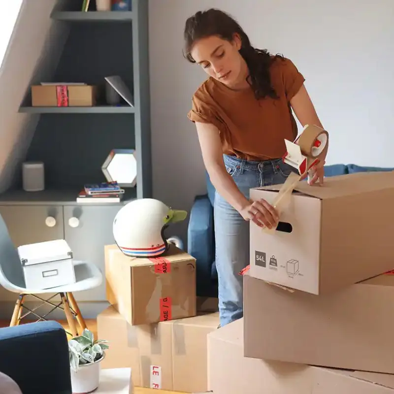 A woman packing boxes in a living room