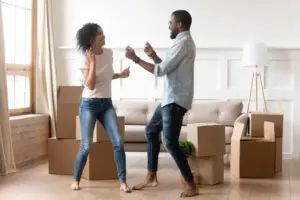 A man and woman dancing in their new home with the help of small move movers.