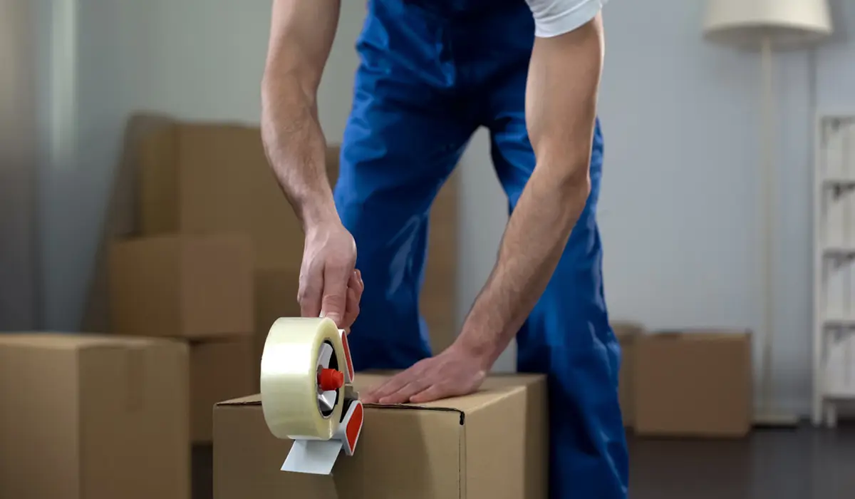 A man taping a box. Find n expert for small moves.
