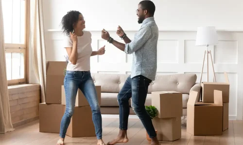 A man and woman dancing in their new home with the help of small move movers.